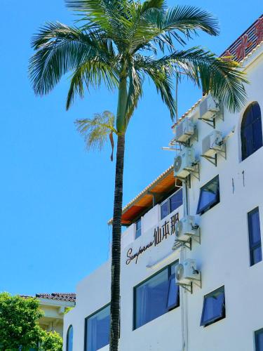 a palm tree in front of a building at Shenzhen Semporna Beach Sea View B & B - 深圳较场尾仙本那沙滩海景民宿 in Shenzhen