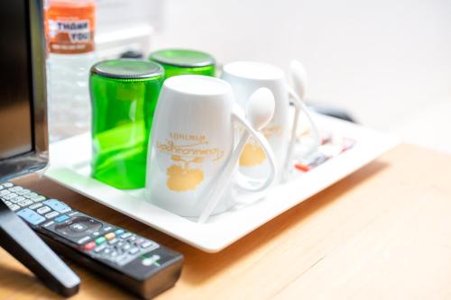 a desk with two coffee cups and a remote control at Tamnanpar Resort in Ban Phe