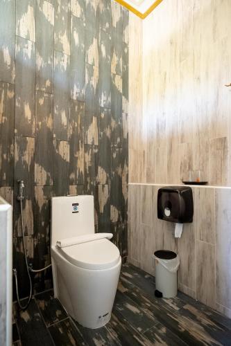 a bathroom with a toilet and a trash can at Tamnanpar Resort in Ban Phe