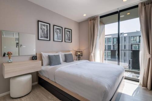 a bedroom with a large bed and a large window at Modern Condo in Nimman (F707) by Pimolplace in Chiang Mai