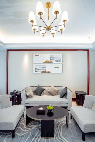 a living room with a couch and two chairs and a table at Yancheng Shuicheng Hotel in Yancheng