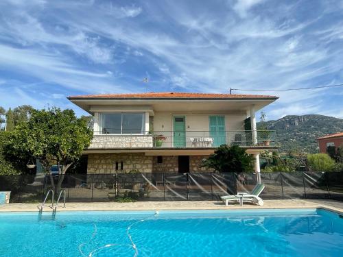 a villa with a swimming pool in front of a house at Bas de villa avec accès piscine près de Nice Cannes Monaco in Carros