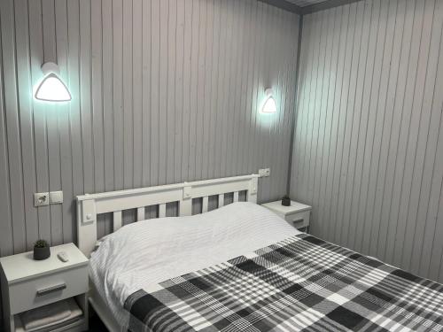 ein Schlafzimmer mit einem Bett und zwei Nachttischen und zwei Lichtern in der Unterkunft Sonna in Podzakharychi