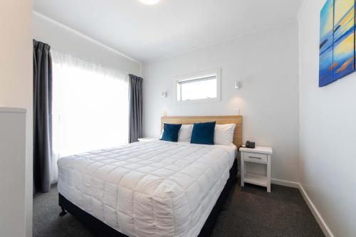 a bedroom with a large bed and a window at Aarangi Motel in Auckland