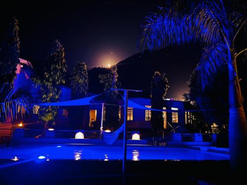 a house lit up at night with blue lights at Hills and Horizon Resort in Benighāt