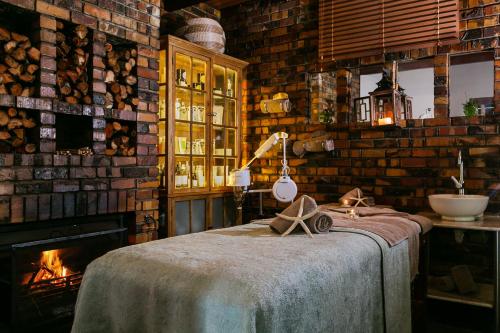 Habitación con chimenea y cama con mesa. en Camps Bay Retreat Hotel en Ciudad del Cabo