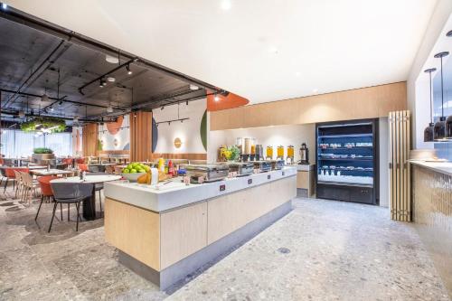 a large kitchen with a counter and a table at Holiday Inn Dandenong by IHG in Dandenong