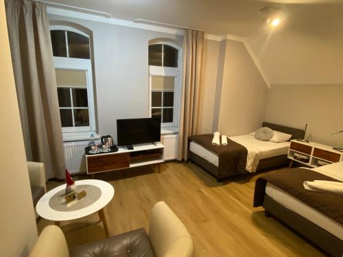 クフィジンにあるHotel Kamilのベッド2台とテレビが備わる小さな客室です。