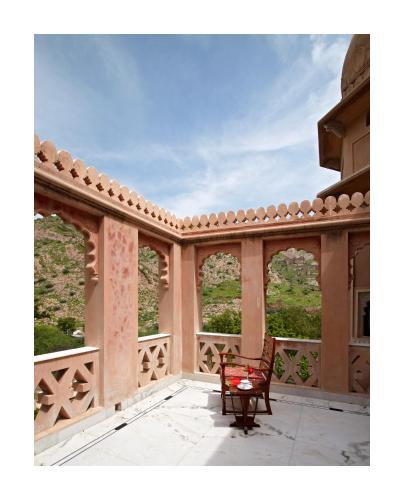 an empty balcony with a chair on a patio at Patan Mahal in Pātan