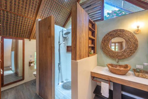 een badkamer met een wastafel, een douche en een spiegel bij Camanolo Homestay in General Luna