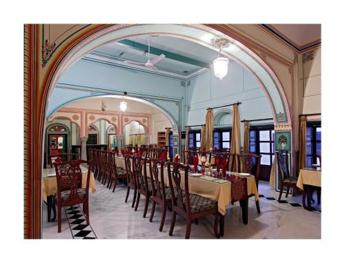 a dining room with a long table and chairs at Patan Mahal in Pātan