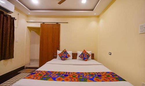 een slaapkamer met een groot bed in een kamer bij FabExpress Golden Imperial in Taliganja