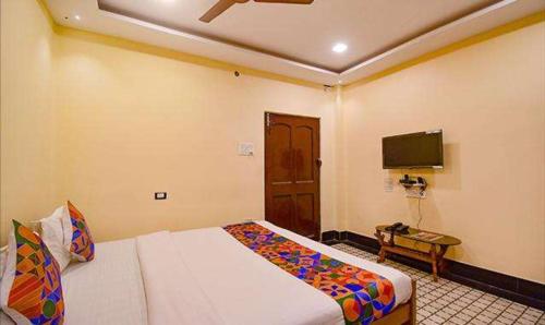 a hotel room with a bed and a tv at FabExpress Golden Imperial - Nr Gariyahat Market in Taliganja