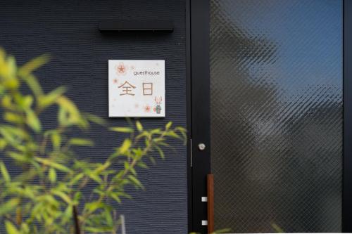 a black door with a white sign on it at Guesthouse ZenNichi in Kyoto