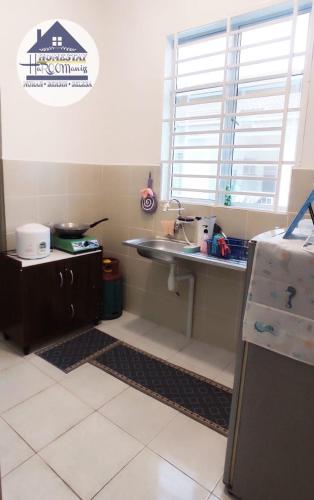 a kitchen with a sink and a window at HOMESTAY haROOManizz in Kangar