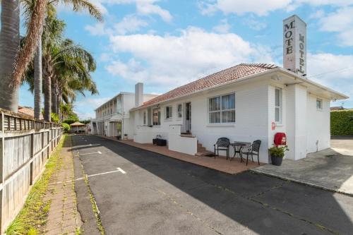a white building with a clock tower on a street at Aarangi Motel in Auckland