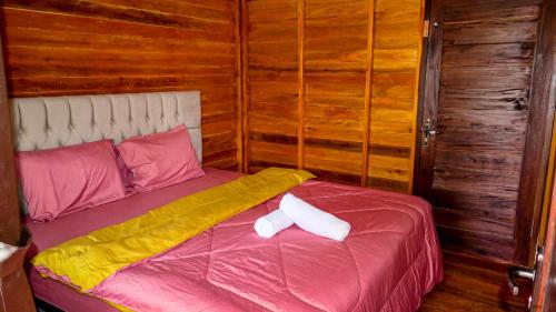 1 dormitorio con 1 cama con 2 almohadas en Mandalika Queen Hostel, en Kuta Lombok