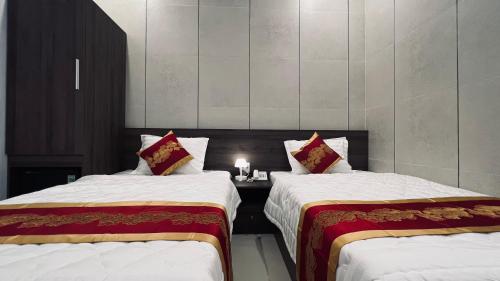 una habitación con 2 camas y una mesa con una vela en Huy Hoàng Hotel en Phan Thiet