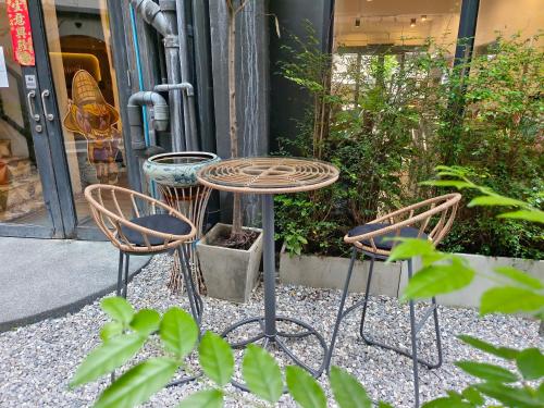 a table and three chairs sitting in front of a store at Rema residence China town in Bangkok