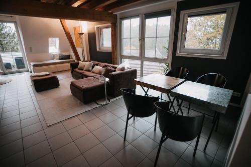 ein Wohnzimmer mit einem Tisch, Stühlen und einem Sofa in der Unterkunft Komplettes Maisonettehaus in idyllischer Lage in Schwabach