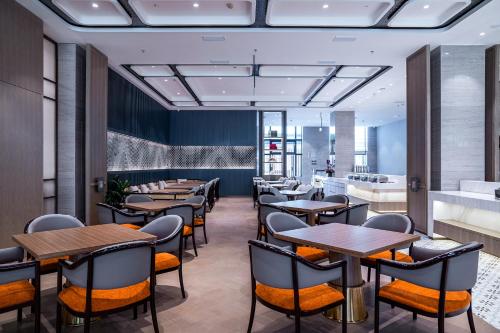 a restaurant with tables and chairs in a room at Yancheng Shuicheng Hotel in Yancheng