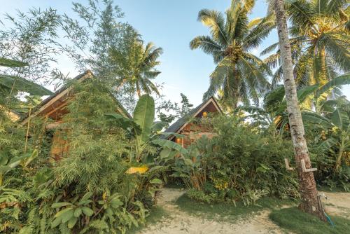 a resort on the beach with palm trees at Camanolo Homestay in General Luna