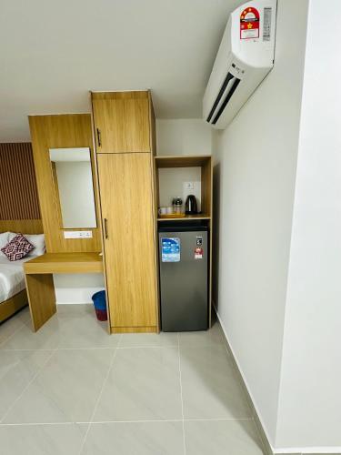 a room with a small refrigerator and a bed at Cozy Hotel@ KL Sentral in Kuala Lumpur