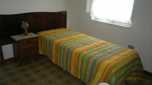 a bedroom with a bed with a colorful comforter at Casa Salvaggio in Grotte
