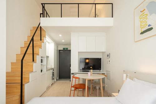 a bedroom with a bed and a table and a staircase at Urbanstay Dangjin Terminal in Dangjin