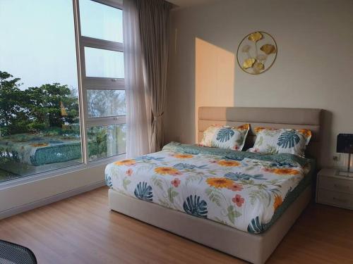 a bedroom with a bed and a large window at F1E DeOwl Beachfront Balcony Seaview karaoke condo in Tanjung Bungah