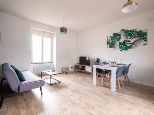 a white living room with a table and chairs at Aux Lilas - Hyper Centre - Wifi - 5 personnes - Rêve au Mans in Le Mans