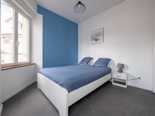 a blue and white bedroom with a bed and a window at Aux Lilas - Hyper Centre - Wifi - 5 personnes - Rêve au Mans in Le Mans