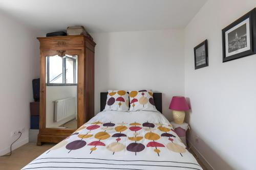 1 dormitorio con 1 cama con un edredón colorido en Cassiopée - Jacuzzi - Unique - 8p - Rêve au Mans en La Bazoge