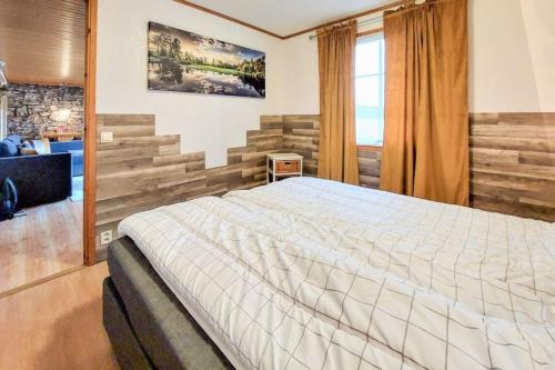1 dormitorio con 1 cama grande en una habitación en Minnebo stuga, en Hässleholm