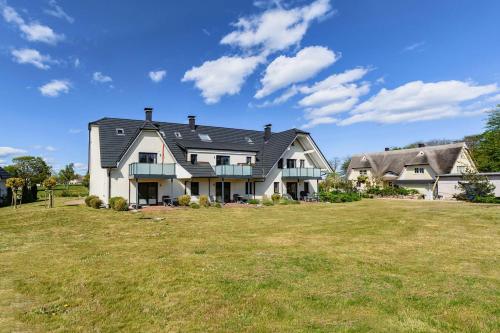 ein großes Haus mit einem großen Rasenplatz in der Unterkunft Mönchgut - Strand Resort Rex Rugia App 05 in Lobbe