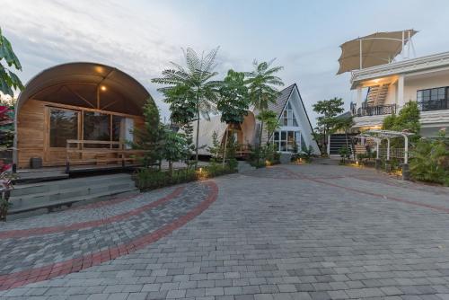 a house with a stone driveway in front of a building at Urbanview Hotel Khayrizsan Tasikmalaya by RedDoorz in Tasikmalaya