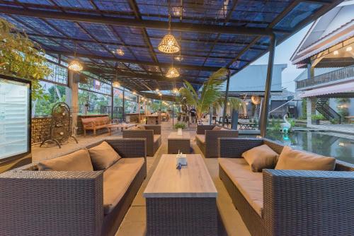 a restaurant with tables and chairs and a pool at Urbanview Hotel Khayrizsan Tasikmalaya by RedDoorz in Tasikmalaya