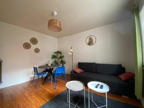 - un salon avec un canapé et une table dans l'établissement Grand T2 très fonctionnel à deux pas du centre - Morel Ladeuil, à Clermont-Ferrand