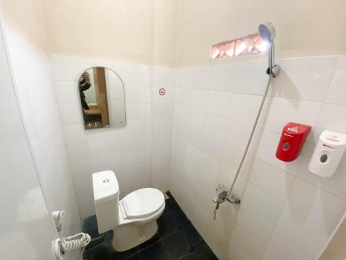 a small bathroom with a toilet and a mirror at PLUM Xpress Buduran in Buduran