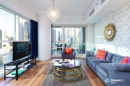 uma sala de estar com um sofá e uma televisão em Dream Inn Apartments - Al Sahab em Dubai