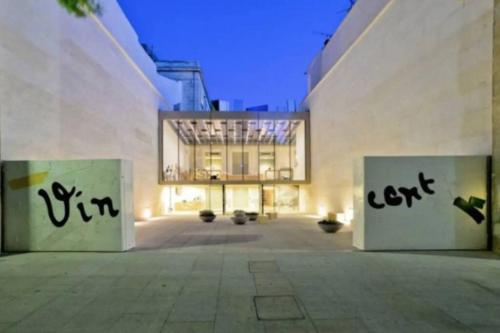 un edificio con dos puertas con graffiti. en Arlette la petite maison Arlésienne, en Arles