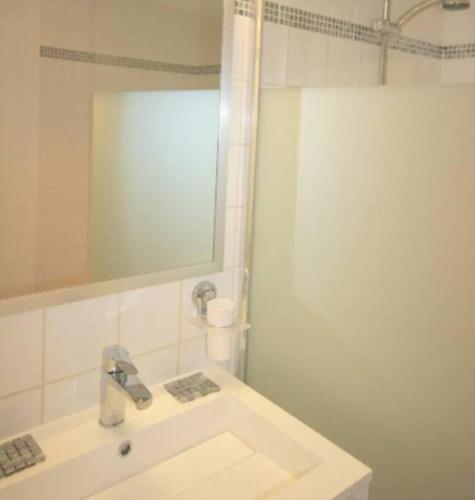 une salle de bain blanche avec un lavabo et un miroir dans l'établissement Arlette la petite maison Arlésienne, à Arles