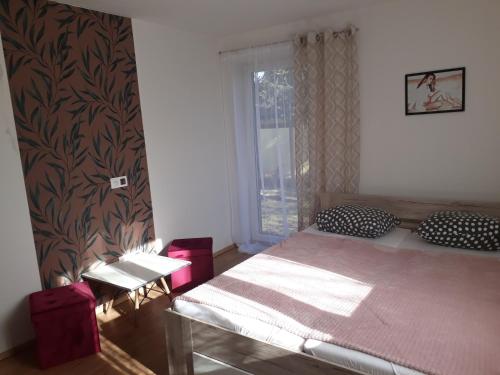 1 dormitorio con cama, mesa y ventana en 3 izbovy RD - bungalow, en Bernolákovo