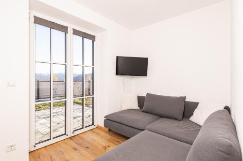 uma sala de estar com um sofá e uma grande janela em Apartment - Lärchenhof em Mauterndorf