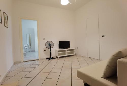a living room with a television and a tiled floor at Appartamento La Fisarmonica Recanati in Recanati