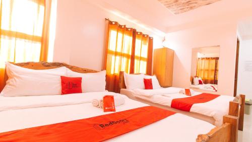 a bedroom with two beds with red pillows at RedDoorz Plus @ Jollydays Hotel Nueva Ecija in San Jose