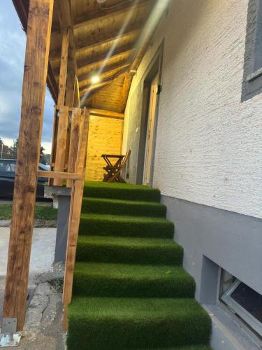 a stairway leading to a building with green grass at Venite Rooms in Velika