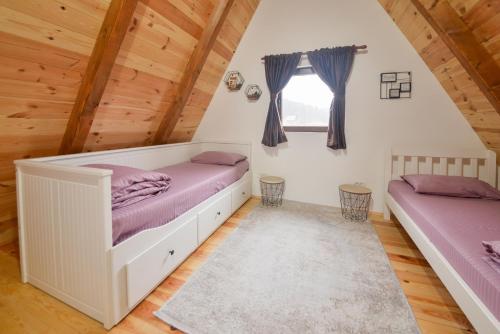 a bedroom with two beds in a attic at Lux Villas Zabljak in Žabljak
