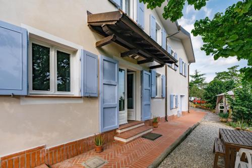 a house with blue shutters and a patio at Caterina e l'Indaco in Sarzana