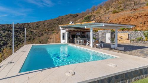 una piscina en una casa con una montaña en Cortijo La Envarra El Borge by Ruralidays, en Moclinejo